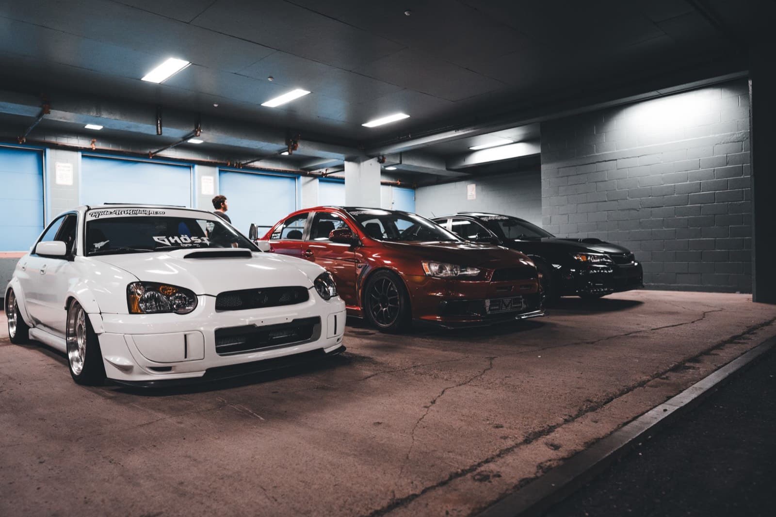 A Subaru WRX STI, a Mitsubishi Evo and friends lined up at a meet