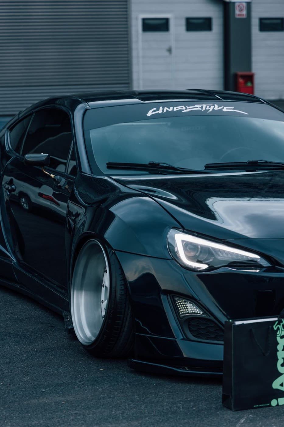 A black widebody sports car with a low stance